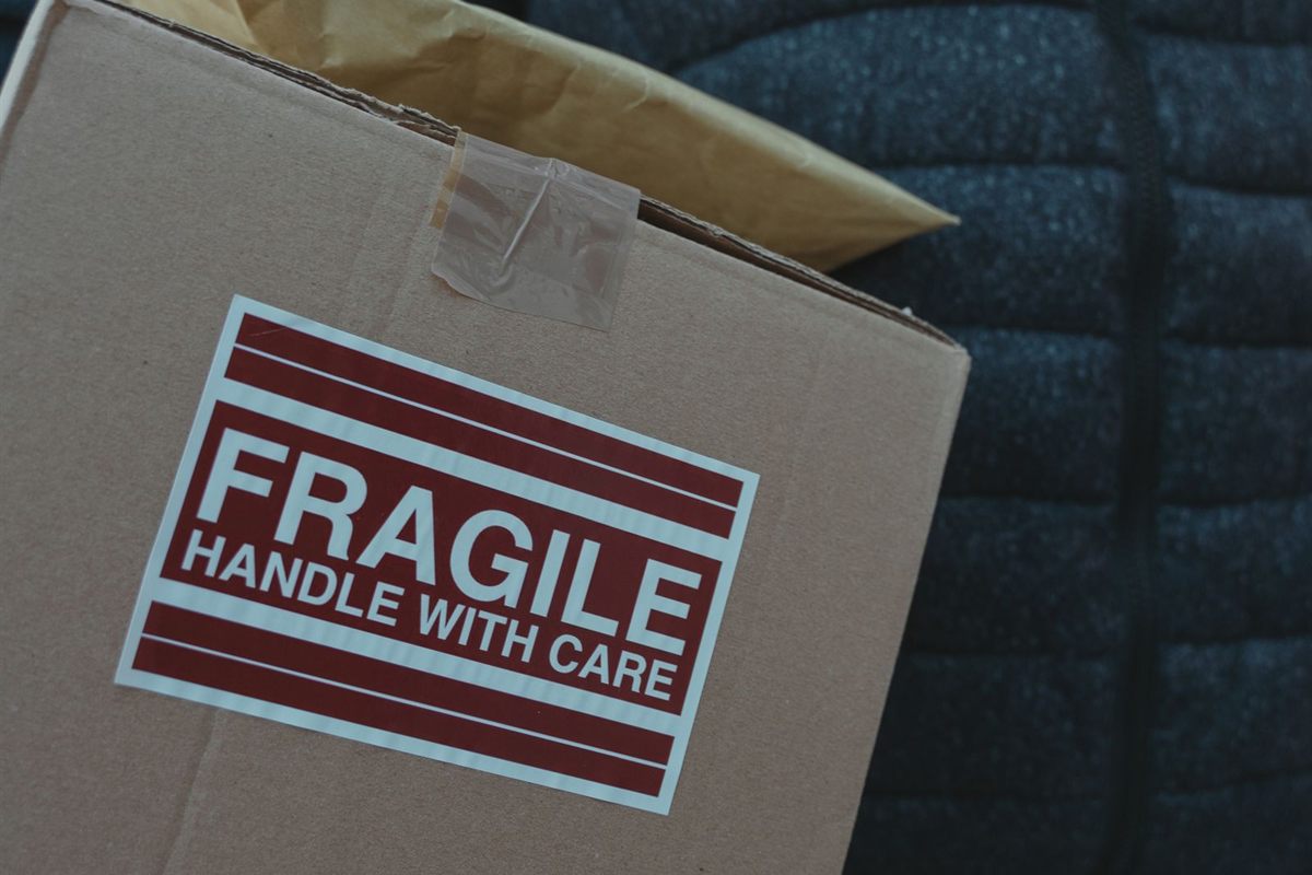 A taped cardboard box with a large fragile handle with care label