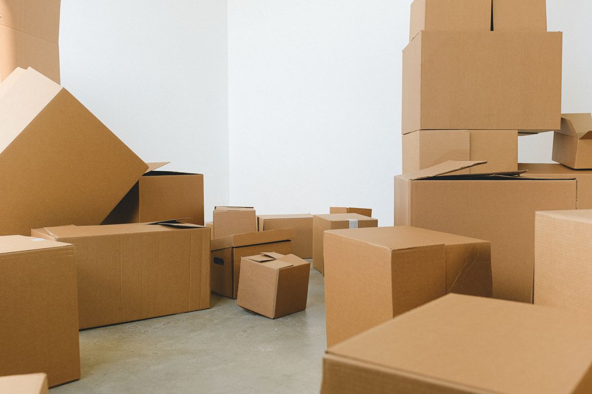 Stacks of plain cardboard boxes waiting in a bright white room
