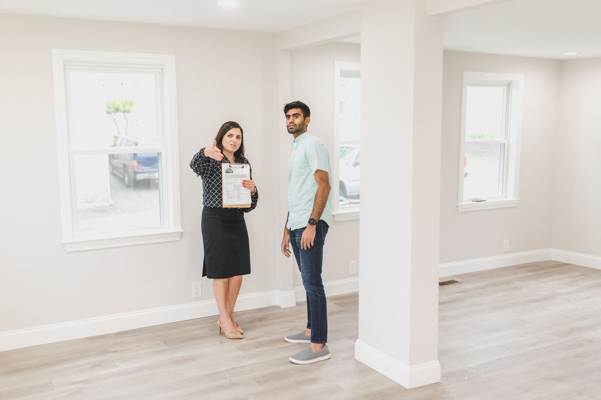 An estate agent showing a buyer around the interior of a new home