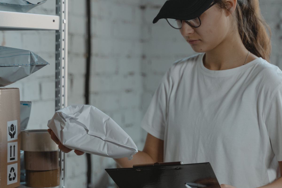 A small online store owner packing a parcel in a stockroom