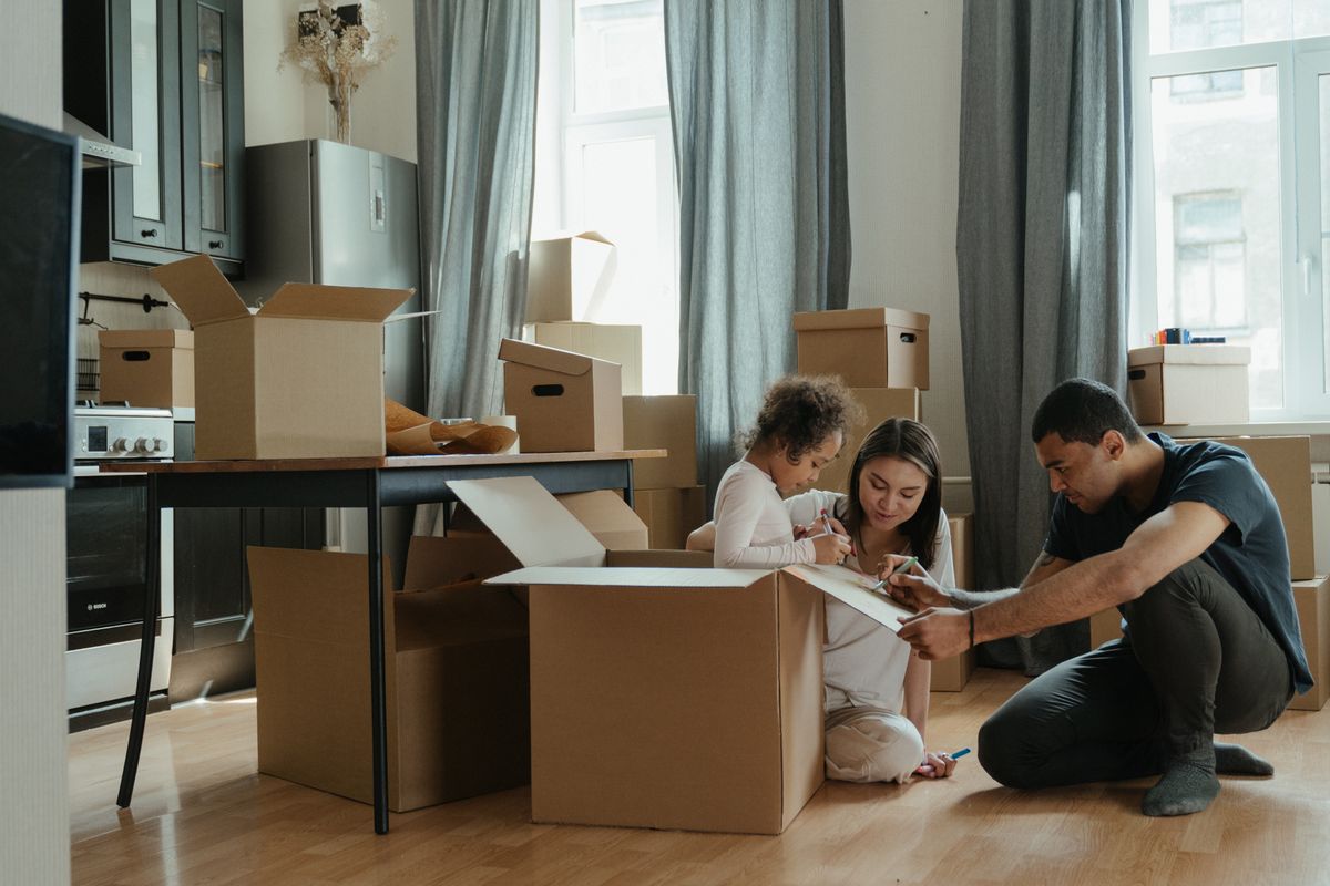 A family unpacking boxes together in the kitchen of their new home