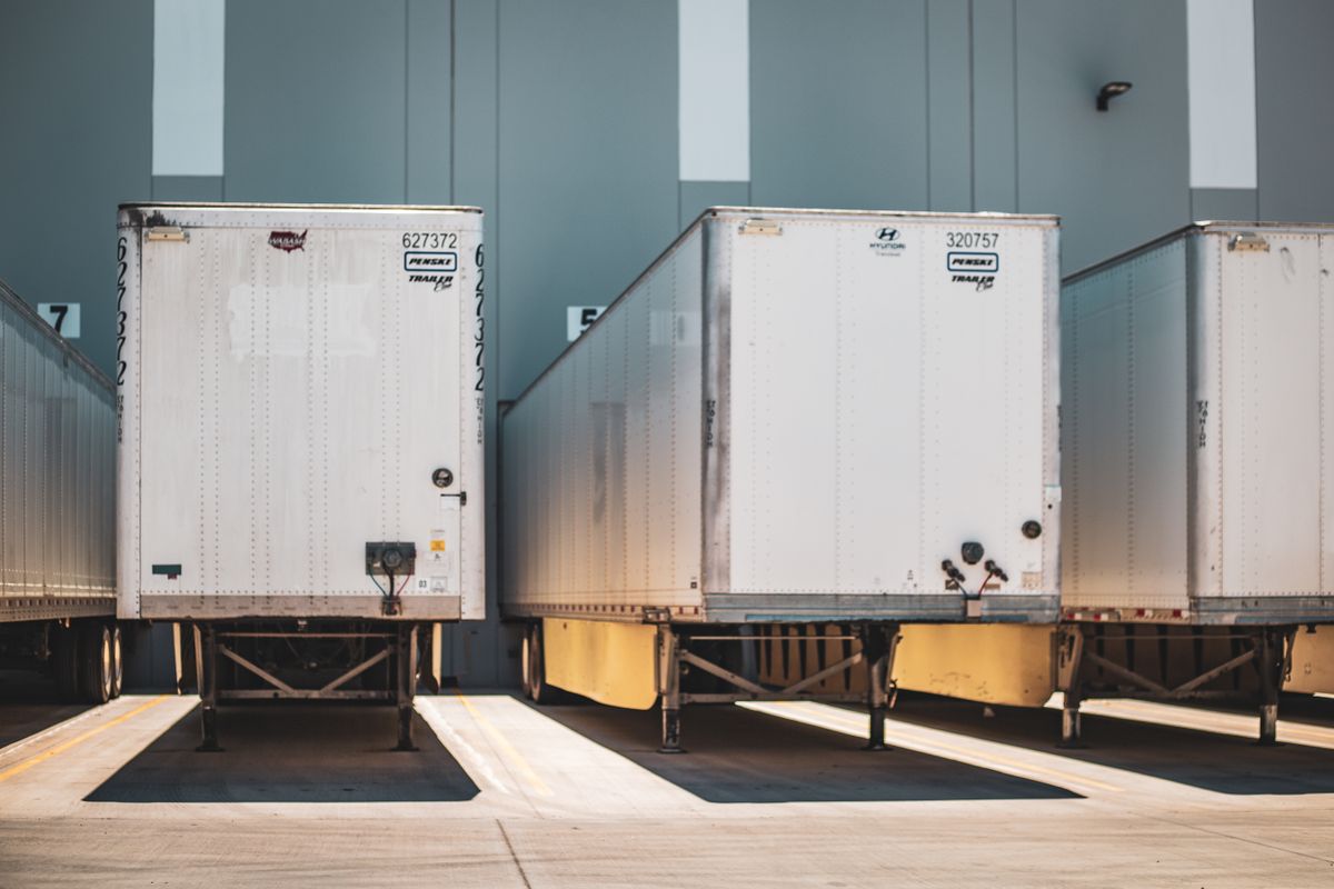 Freight trailers backed into numbered loading dock doors at a warehouse