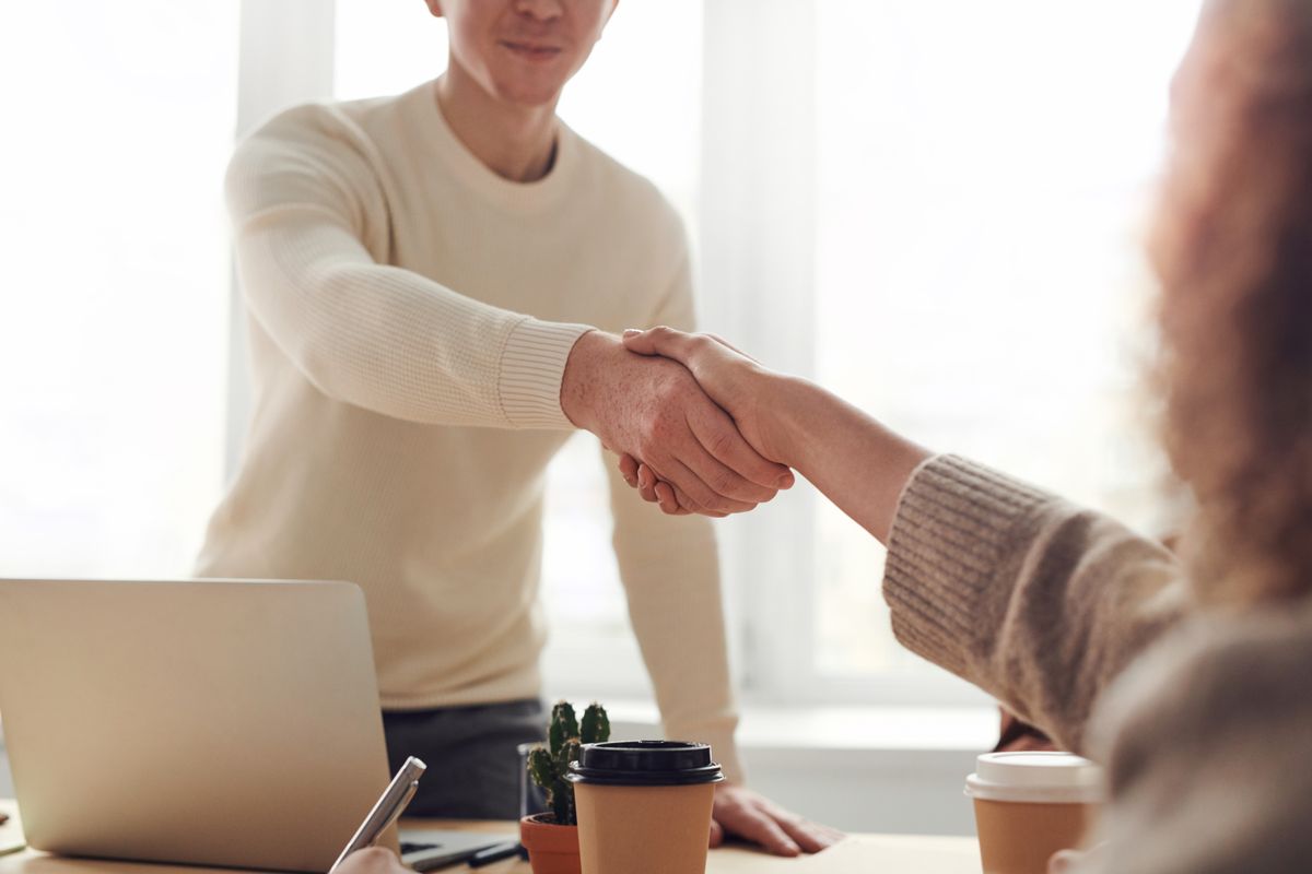 A store owner shaking hands with a business partner across a desk